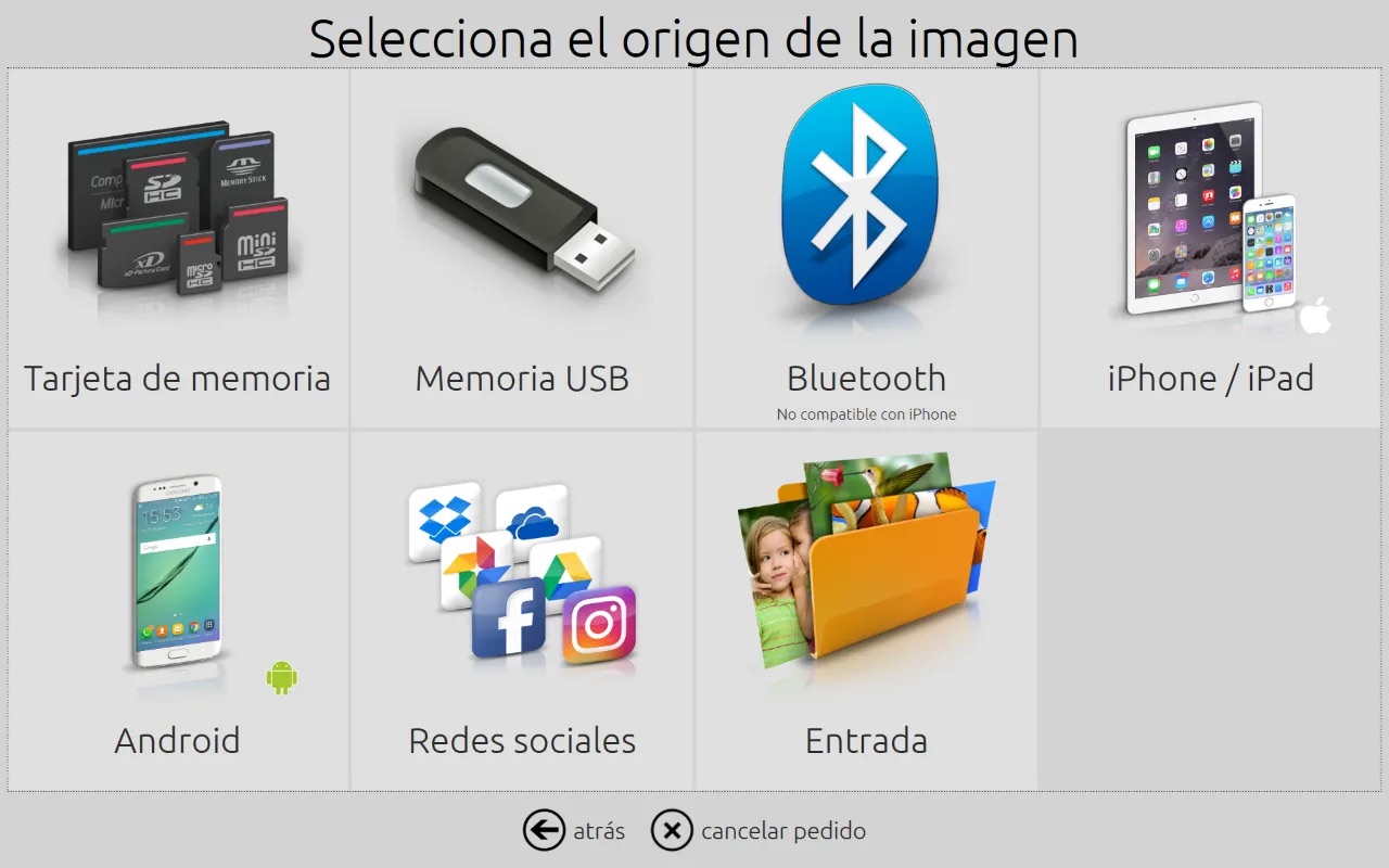 Captura de pantalla que muestra la pantalla de inicio de DiLand Kiosk que muestra las fuentes disponibles de adquisición de las fotos: tarjetas de memoria, USB, Bluetooth, iPhone/iPad, Android,Redes sociales y una carpeta llamada Entrada. La cominación de colores es un tema claro.